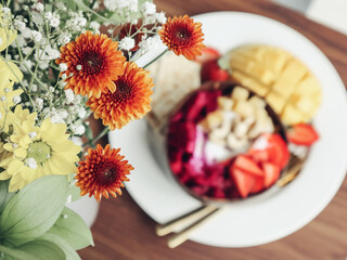 Obraz na płótnie Canvas Flowers bouquet with smoothie bowl on background closeup