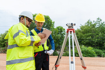 The engineer consulted with the contractor on road construction guidelines by using a telescope to...