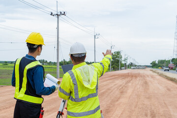 Engineers and contractors plan together on site to work on a rural highway road.