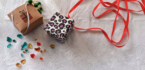 A small box and a bag for presents, colorful glass stones and a red ribbon