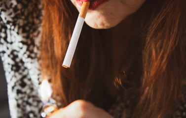 Frau z&uuml;ndet sich eine Zigarette an