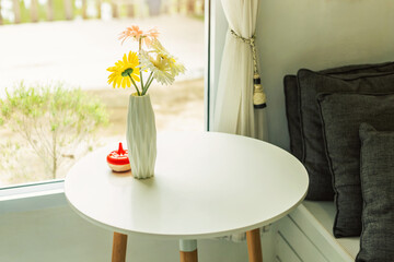 Tables and chairs in a coffee shop There were dried flowers in a vase placed above.