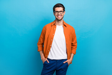 Portrait of nice confident young person toothy smile put hands pockets posing isolated on blue...
