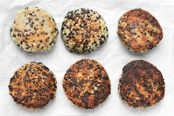 Delicious vegan cutlets with sesame on parchment paper, flat lay