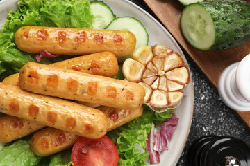 Delicious grilled vegan sausages with fresh herbs and vegetables on grey table, flat lay