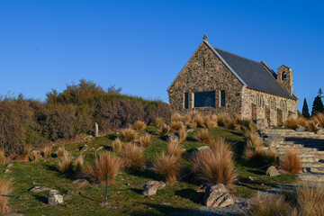 Fototapeta na wymiar The Church of the Good Shepherd late in the afternoon on a sunny day in Lake Tekapo, New Zealand