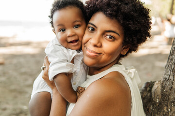 Pretty happy woman holding a newborn baby in her arms.