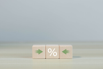 Financial interest rate holding wooden block with percentage sign and up arrow, financial growth,...