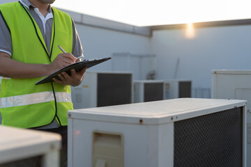 Asian maintenance engineer works on the roof of factory. contractor inspect compressor system and...