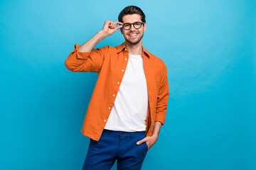 Portrait of positive smart executive director toothy smile good mood hand touch eyeglasses isolated on blue color background