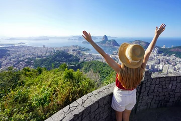 Poster Aerial view of happy young tourist woman with raising arms on belvedere terrace with Guanabara Bay in Rio de Janeiro, Brazil © zigres