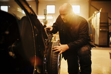 Fototapeta na wymiar Mature man working on a car in the workshop