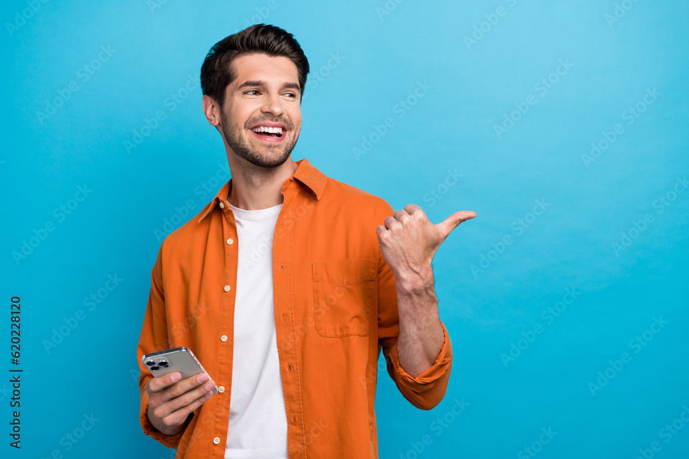 Poster portrait of attractive cheerful person toothy smile hold apple iphone look indicate finger empty spa