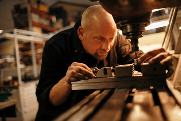 Mature man working with a machine in the workshop