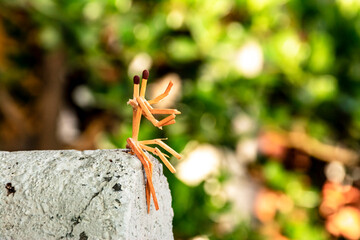 abstract photograph of matches personifying people. conceptual image of men made of matches sitting, watching the sunset from the edge of a rock. concept of people keeping each other company.