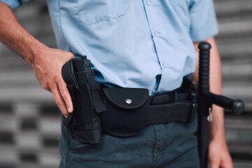 Hand, gun and security with an officer on duty or patrol in the city for safety and law...