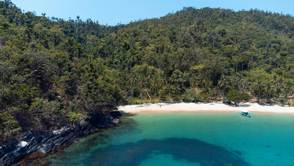 Piękny tropikalny widok, ujęcie z drona na rajską plażę, piasek, woda i palmy.