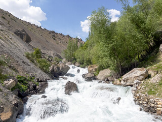 Fototapeta na wymiar Water rushes through the mountain valley