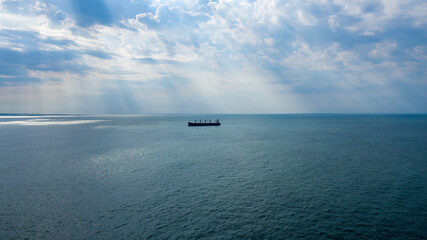 Self-unloading bulk carrier at Rio De La Plata anchorage. Sun rays shining through clouds.  Aerial...