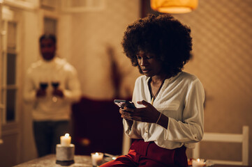 Portrait of a beautiful african american woman using a smartphone at home