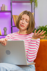Displeased young woman use laptop notebook typing browsing working, loses becoming surprised sudden...