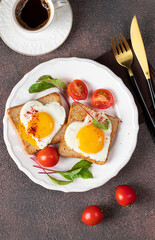 Heart-shaped fried eggs on toast with cherry tomatoes and a cup of coffee for breakfast