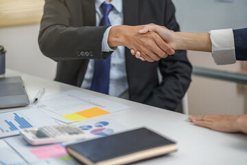 Executives business partnership handshake in meeting room..