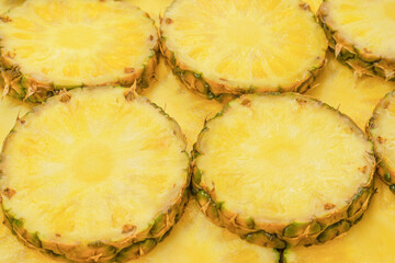 Pineapple juicy yellow slices as a background.