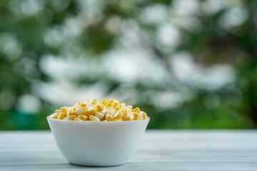 Bowl with corn seeds on a table