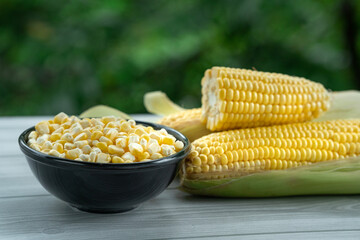 Corn advertising image, Fresh corn on the cobs with seed on black bowl