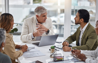 Businessman, laptop and teamwork with documents in meeting for strategy, planning or proposal at...