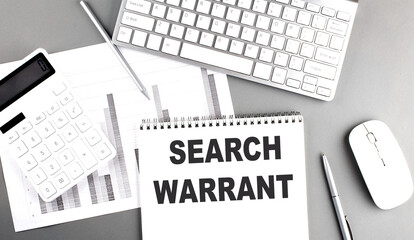 SEARCH WARRANT text written on notebook on grey background with chart and keyboard, business concept