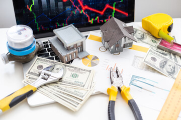 House construction plan concept. Tools for building work. Architectural model houses, yellow hard hat, meter and spirit level above blueprint with hammer, silicone gun, wrenches, headphones and gloves