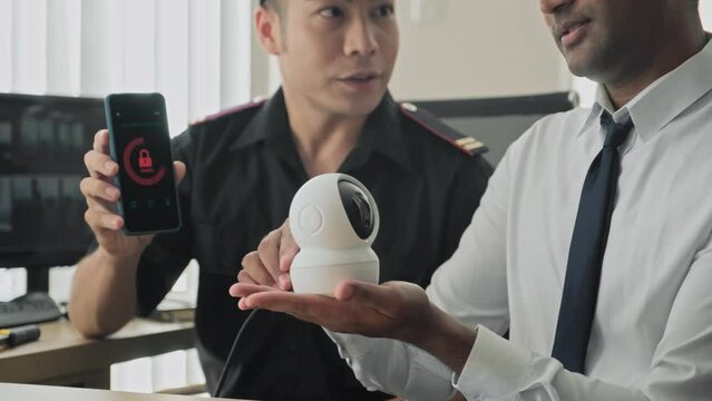 Security guards testing mobile app connected with surveillance camera on workplace