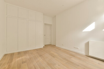 Fototapeta na wymiar an empty room with wood floors and white cabinets on the wall to the right, there is no one door