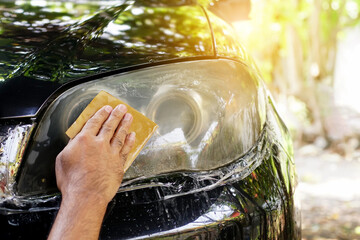 Male hands polishing car headlights, car lamp or front headlight polishing, renewed headlamp,...