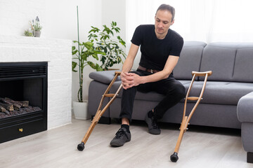Disabled Man Using Crutches At Home