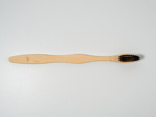Bamboo toothbrush. Wooden toothbrush on a white background. Toothbrush close-up.