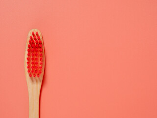 Bamboo toothbrush. Wooden toothbrush on a pink background. Toothbrush close-up.