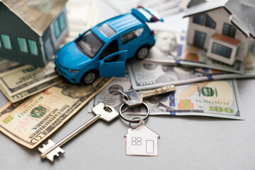 mortgage, investment, real estate and property concept - close up of home model, money and house keys.