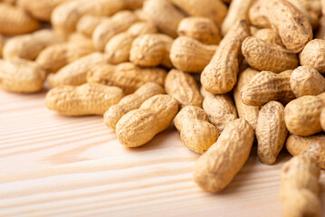Some peanuts in shell on wooden table. Close up of unpeeled peanuts background