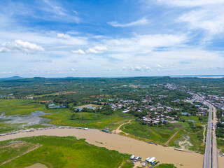 Aerial view of National Route 20 in Dong Nai province, group of floating house on La Nga river, Vietnam with hilly landscape and sparse population around the roads.