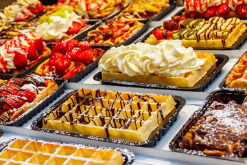 Belgian waffles with colorful sweet toppings and fruits for sale in Brussels, Belgium