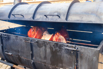 Czech smoked ham cooking on charcoal spit roaster in Prague streets, Czech Republic