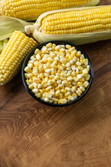Fresh Corn seed on a black bowl isolated on wooden table