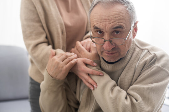 Senior Couple, Happy And Laughing In Their Home With Love, Care And Support For Retirement Lifestyle. Commitment Of A Funny Man And Woman In A Marriage With Trust And Security On A Living Room Couch.