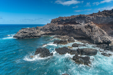   rocky beach with a natural arch with blue sky. La Dehesa. El Hierro island. Canary Islands 