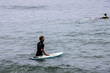 Surfer entering the sea in Maspalomas, Gran Canaria, Spain