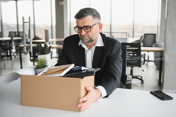 old employee leaving office with the box full of belongings