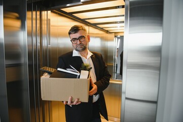Portrait of sad dismissed senior old business man worker taking his office supplies in the box. Pensioner mature retire from work carry staff back home. Lifestyle business retirement, quit job concept